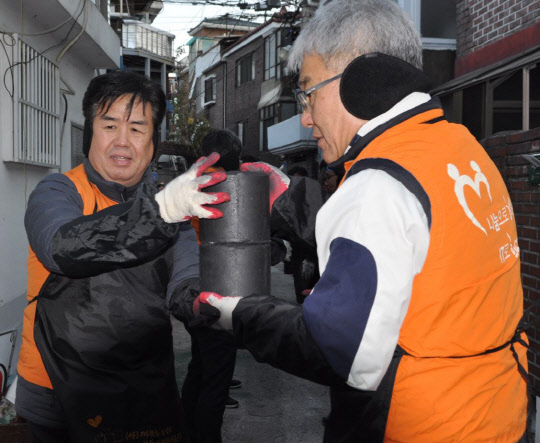 지난 13일 서울 영등포구 도림동 일대에서 정지석 코스콤 사장(왼쪽) 등 코스콤 임직원이 사랑의 연탄 나눔활동을 하고 있다. 코스콤 제공